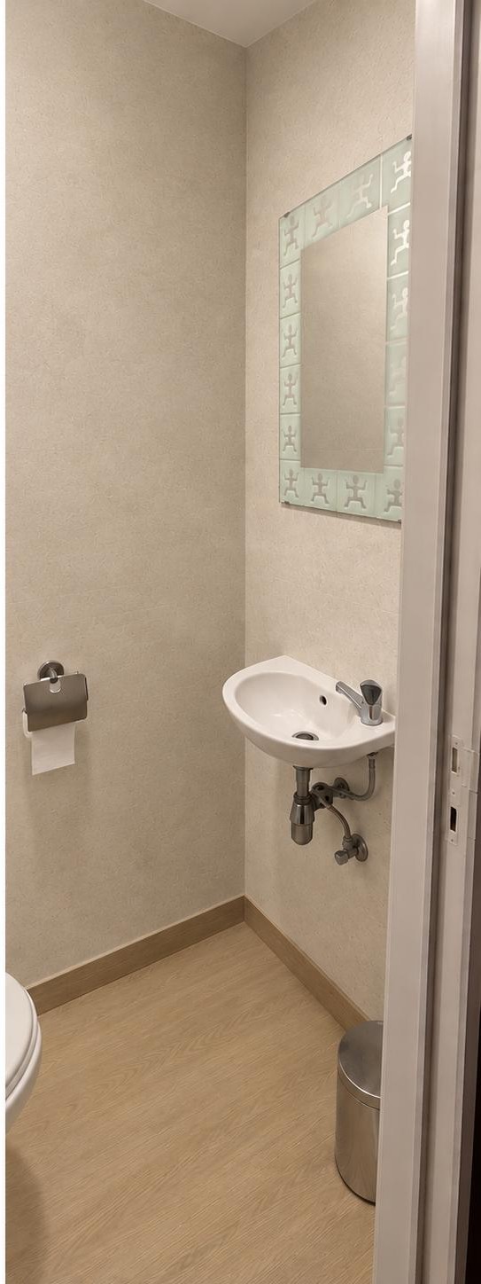 Coin lavabo après rénovation Cover Styl : murs recouverts d’un film effet textile beige